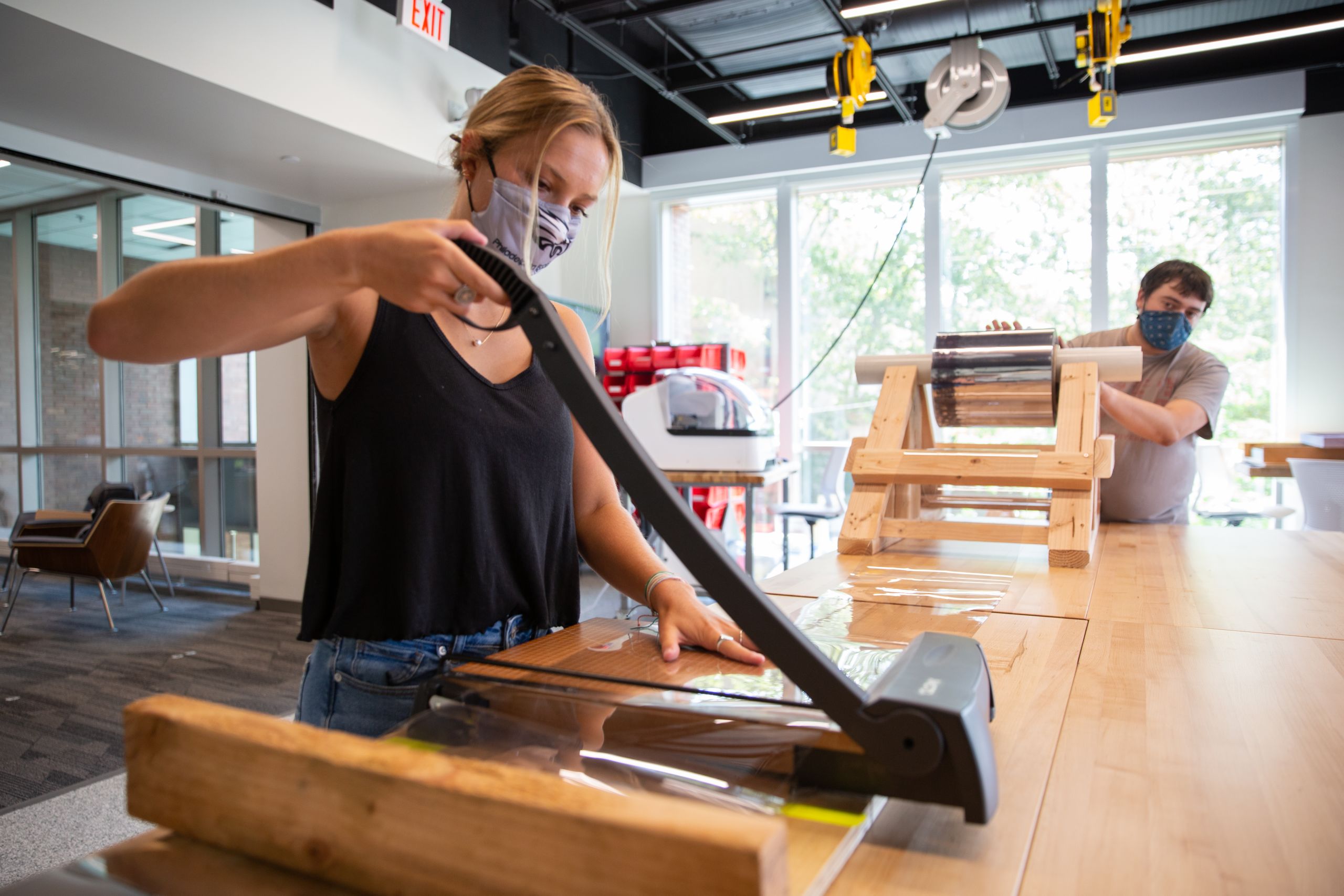 two students assemble face shields.